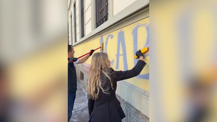 Milano, Salvini e Sardone cancellano scritte contro forze dell'ordine sul muro di una scuola
